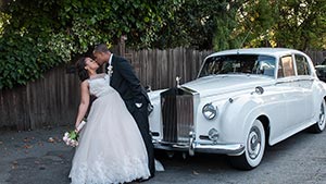 Just Married Couple by Their Getaway Car